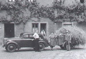 Historische Fotoaufnahme des Pflegeheim Meerholz, davor der Heimleiter an seinem Wagen