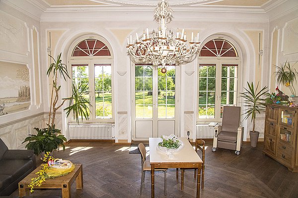 Musikzimmer im Schloss Meerholz mit hoher Decke, großer Fensterfront, Sitzgelegenheiten und Tischen