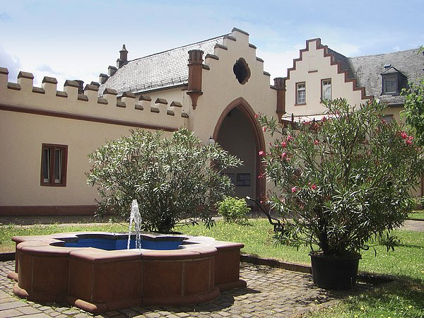 Begrünter Innenhof des Schloss Meerholz, mit einem Brunnen